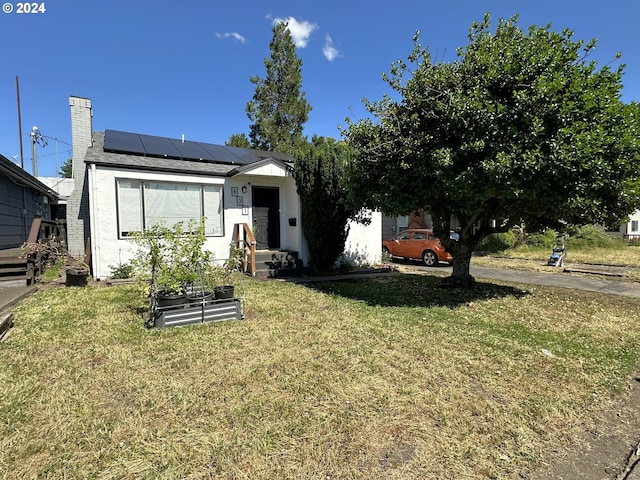 view of front facade with solar panels and a front lawn