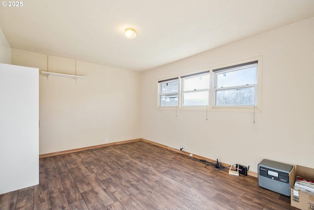 unfurnished room with dark wood finished floors and baseboards