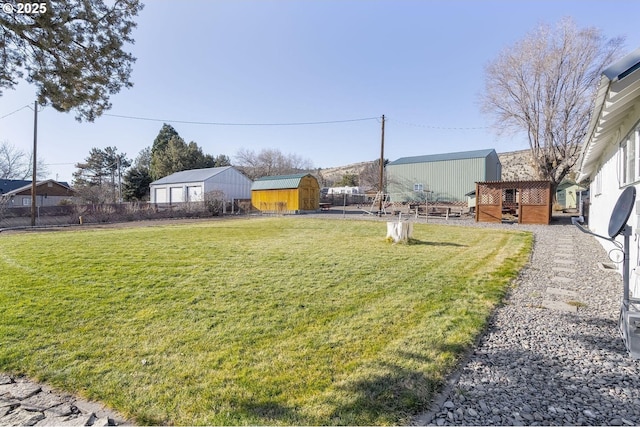 view of yard with a fenced backyard, an outdoor structure, and a storage unit