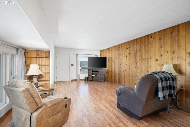 living room with wood walls and wood finished floors