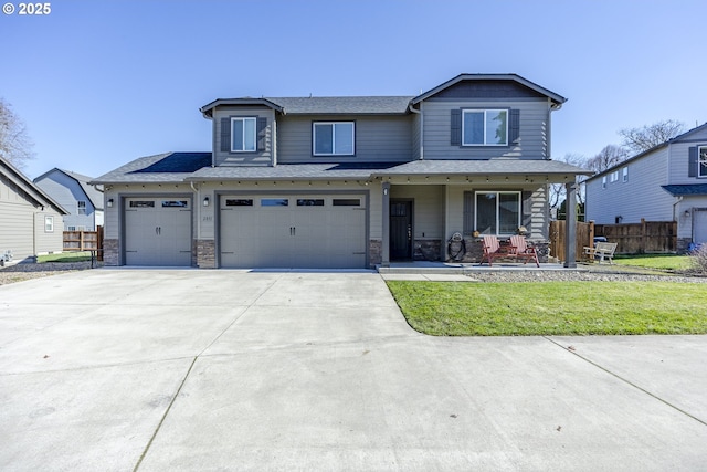 view of front of property with covered porch, a garage, fence, driveway, and a front lawn