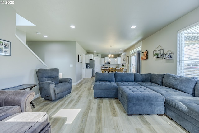 living room with baseboards, light wood-type flooring, and recessed lighting