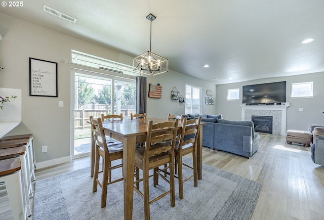 dining room featuring a tile fireplace, recessed lighting, visible vents, baseboards, and light wood-type flooring