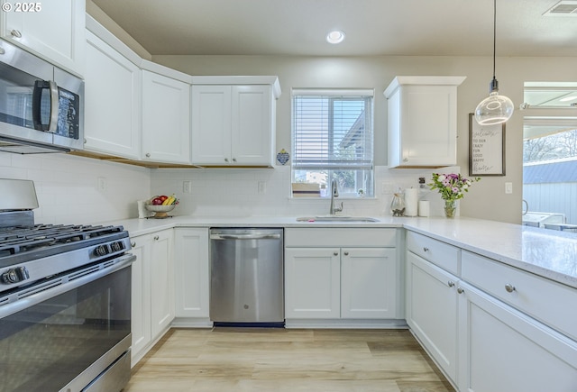 kitchen featuring a sink, visible vents, white cabinets, light countertops, and appliances with stainless steel finishes