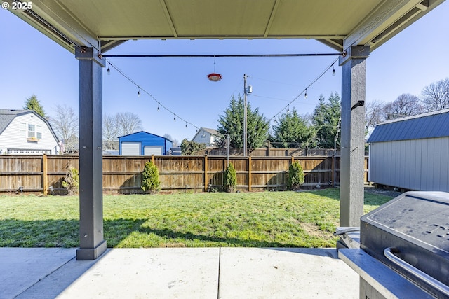 view of patio with an outbuilding, a fenced backyard, and a storage unit