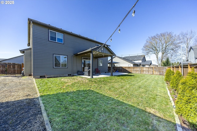 rear view of property featuring crawl space, a patio area, a yard, and a fenced backyard