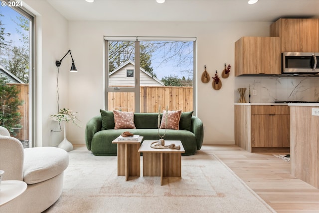 living room with recessed lighting, a healthy amount of sunlight, and light wood-style flooring