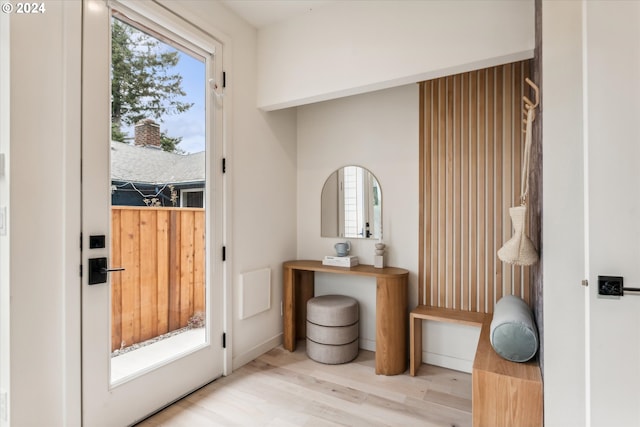 doorway to outside featuring wood finished floors, baseboards, and a wealth of natural light