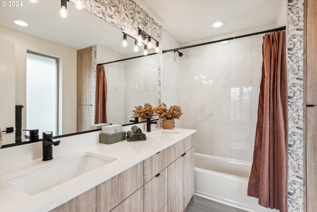 bathroom featuring a sink, double vanity, and shower / tub combo