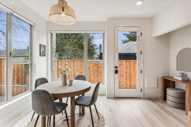 dining space with light wood-type flooring, plenty of natural light, and baseboards