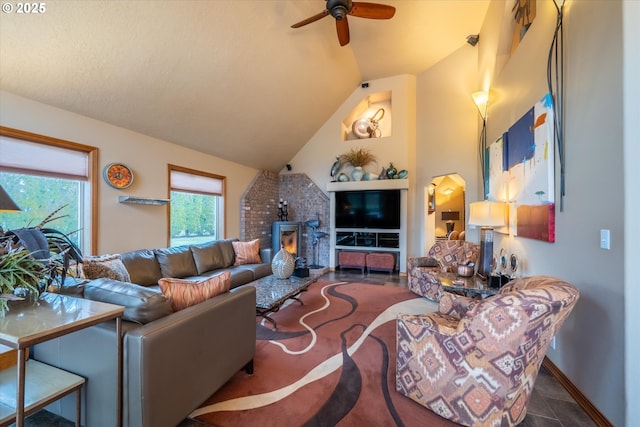 living area featuring plenty of natural light, baseboards, vaulted ceiling, and ceiling fan