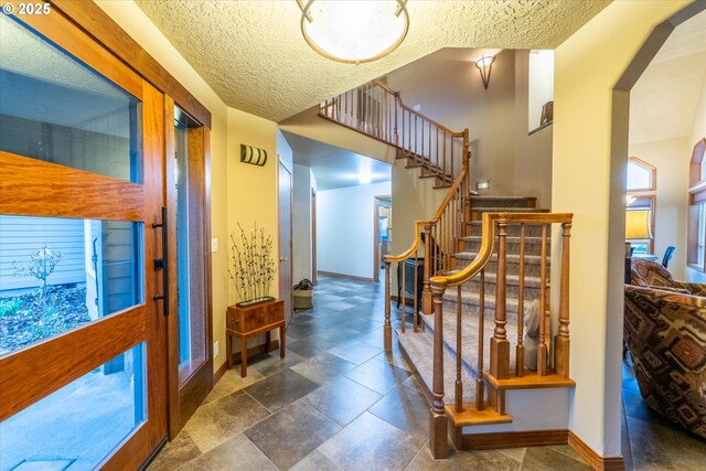 interior space with baseboards, a textured ceiling, and stairway
