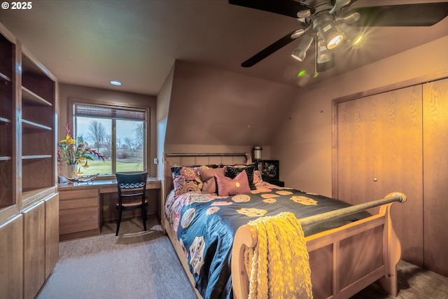 carpeted bedroom with vaulted ceiling and a ceiling fan