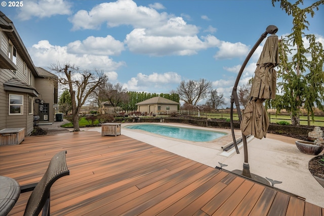 view of swimming pool featuring a wooden deck, a patio, and a fenced in pool