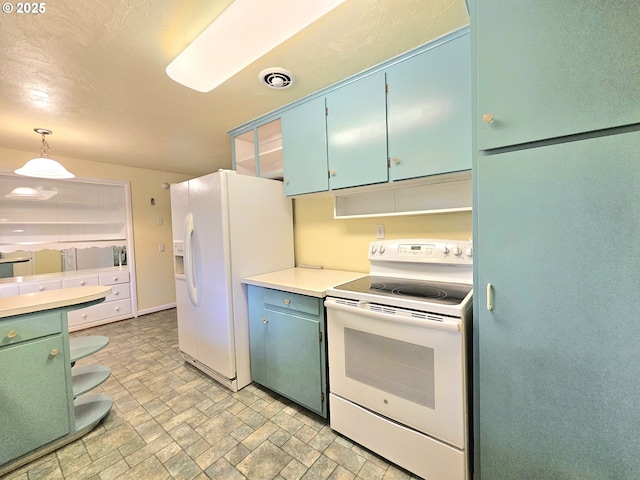 kitchen featuring visible vents, white appliances, light countertops, green cabinetry, and hanging light fixtures