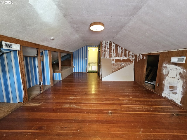 bonus room featuring visible vents, a textured ceiling, vaulted ceiling, and hardwood / wood-style floors