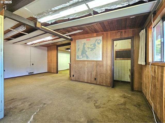 interior space featuring wooden ceiling, carpet flooring, wood walls, and visible vents