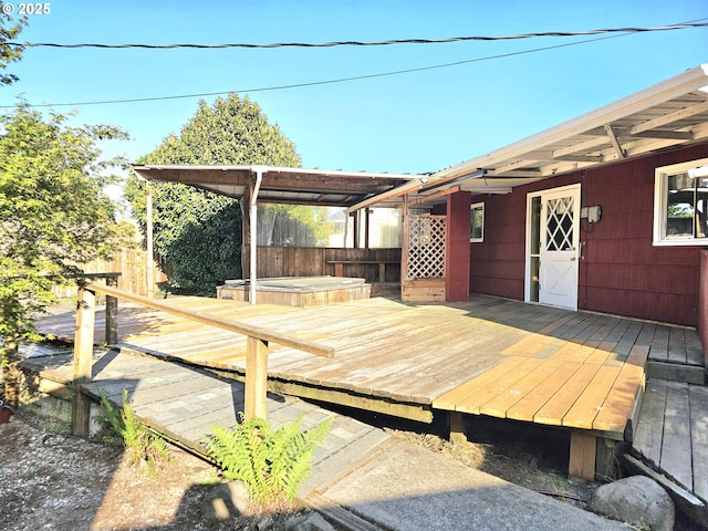 wooden deck with a covered hot tub and fence