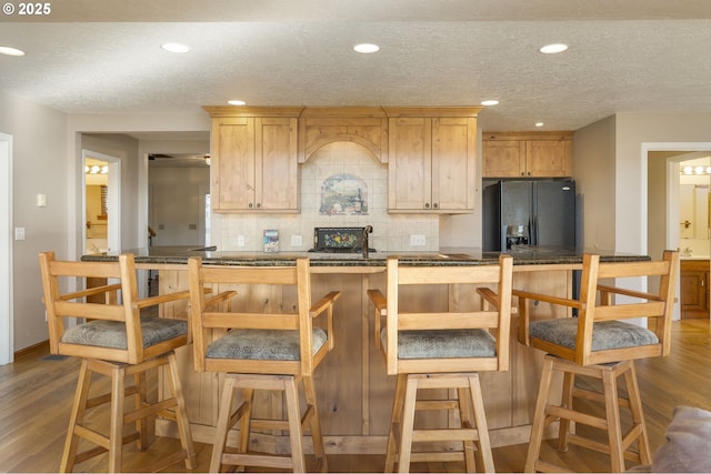 285 W Sunny Sands Rd, Cathlamet, WA 98612 - kitchen with black fridge, dark wood finished floors, backsplash, a textured ceiling, and light brown cabinetry