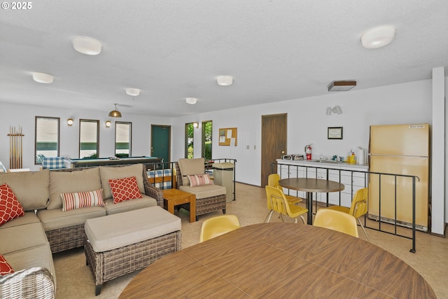 living room with light carpet, billiards table, and a textured ceiling