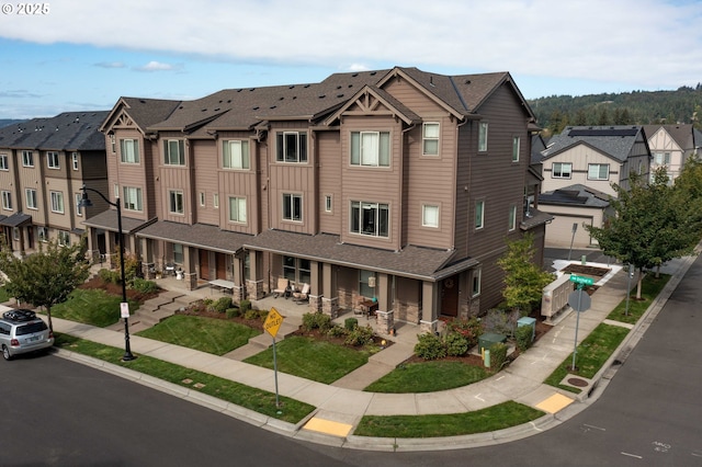 view of front of property with board and batten siding, a residential view, a patio area, and a porch