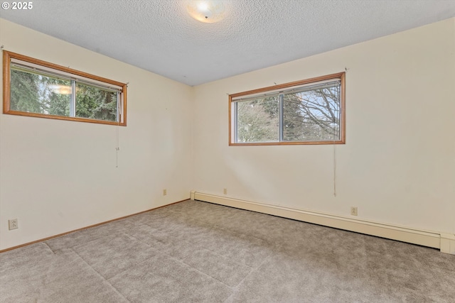 unfurnished room featuring plenty of natural light, baseboard heating, carpet floors, and a textured ceiling