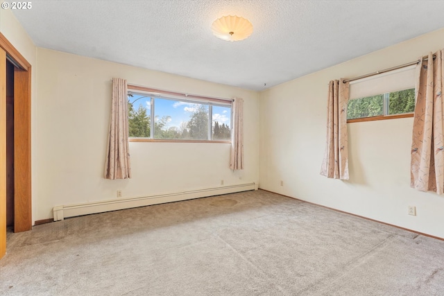 carpeted empty room with a baseboard radiator and a textured ceiling