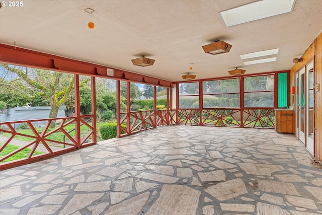 unfurnished sunroom featuring a skylight