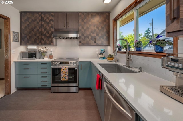 3511 NE Holman St, Portland, OR 97211 - kitchen featuring appliances with stainless steel finishes, ventilation hood, light countertops, backsplash, and recessed lighting