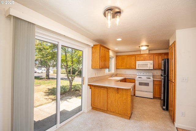 576 S 35th St, Springfield, OR 97478 - kitchen with white appliances, a peninsula, light countertops, healthy amount of natural light, and recessed lighting