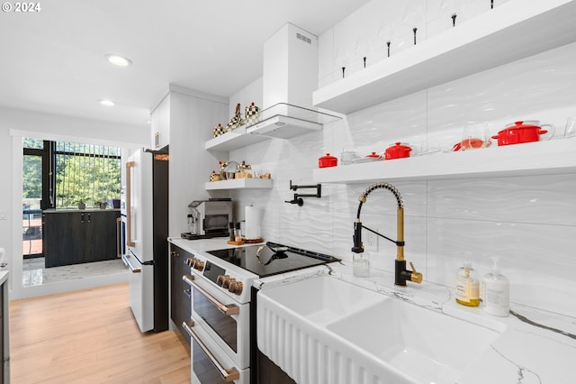 kitchen with decorative backsplash, stainless steel fridge, extractor fan, white cabinets, and range