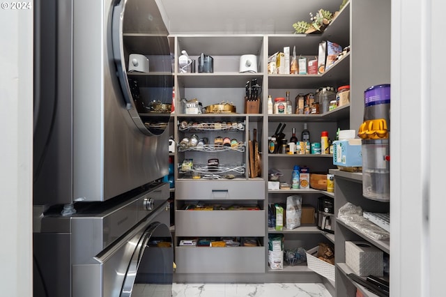 pantry featuring stacked washing maching and dryer