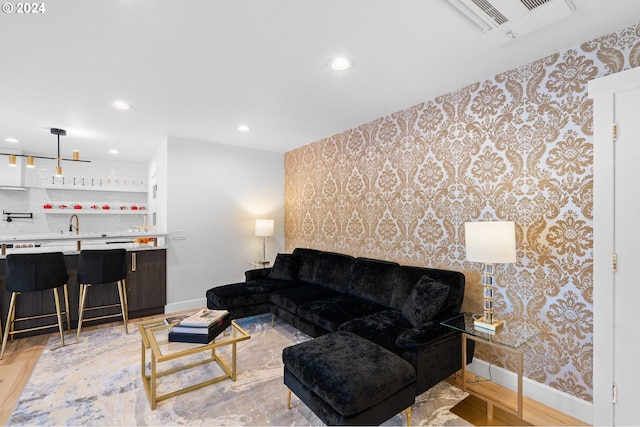 living room with sink and light hardwood / wood-style flooring