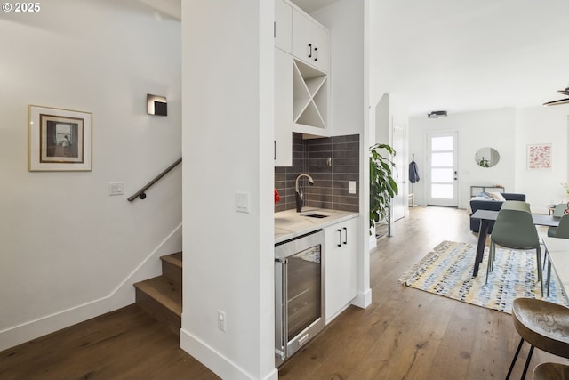 5674 NE 15th Ave, Portland, OR 97211 - kitchen featuring wine cooler, wood finished floors, decorative backsplash, white cabinetry, and light countertops