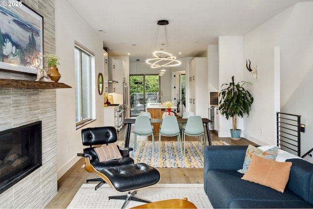 5674 NE 15th Ave, Portland, OR 97211 - living area featuring a fireplace, light wood-style flooring, and a chandelier