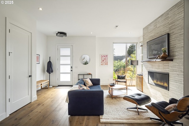 5674 NE 15th Ave, Portland, OR 97211 - living room featuring a large fireplace, wood-type flooring, and recessed lighting