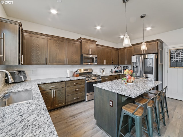 6212 N 87th Ave, Camas, WA 98607 - kitchen with appliances with stainless steel finishes, a sink, light wood-style flooring, a center island, and dark brown cabinetry