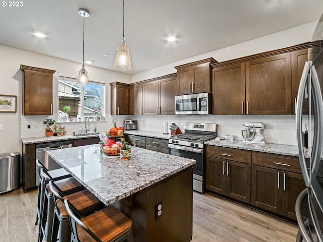 6212 N 87th Ave, Camas, WA 98607 - kitchen with appliances with stainless steel finishes, a kitchen island, tasteful backsplash, light wood finished floors, and recessed lighting