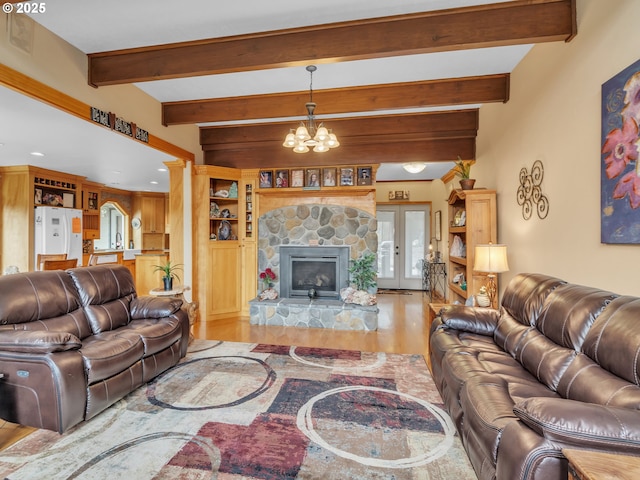 7145 SE Amity Dayton Hwy, Amity, OR 97101 - living area featuring wood finished floors, a chandelier, a stone fireplace, and beamed ceiling