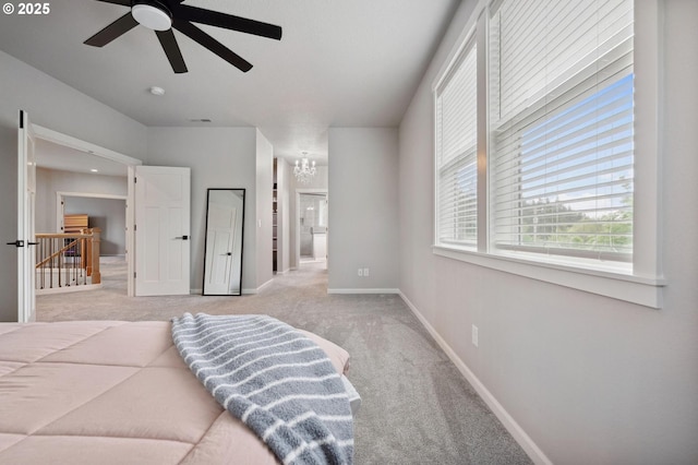 carpeted bedroom featuring an inviting chandelier, connected bathroom, and baseboards