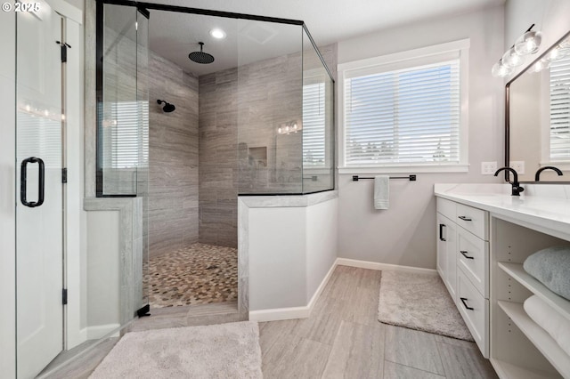 full bath with recessed lighting, baseboards, tiled shower, and vanity