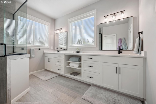 full bathroom with a sink, baseboards, a stall shower, and double vanity