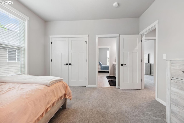 carpeted bedroom featuring baseboards and a closet