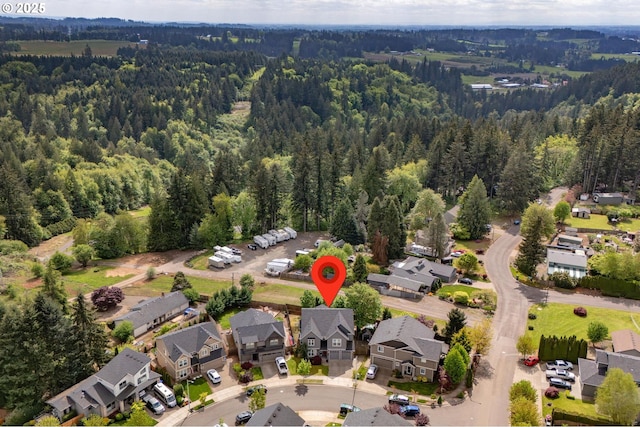 drone / aerial view featuring a residential view and a view of trees