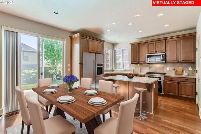 15610 SE Kingbird Dr, Happy Valley, OR 97015 - kitchen with appliances with stainless steel finishes, light wood-style flooring, decorative backsplash, recessed lighting, and a sink