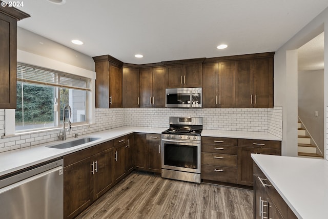 kitchen featuring dark hardwood / wood-style flooring, sink, dark brown cabinets, and stainless steel appliances