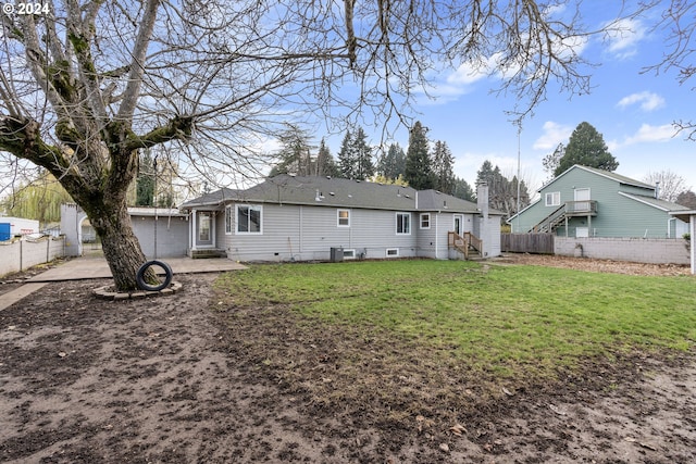 rear view of house featuring a lawn and central air condition unit