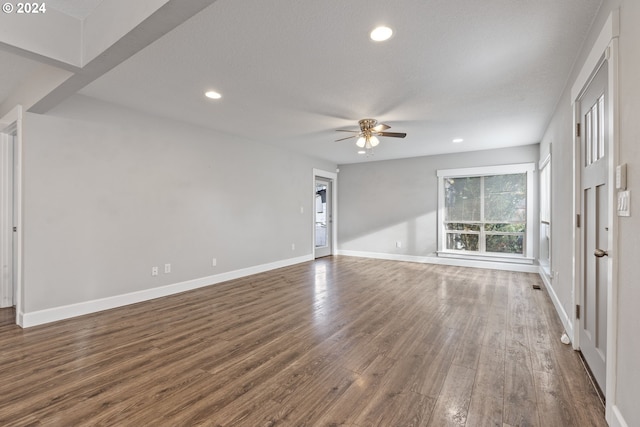 unfurnished living room featuring a textured ceiling, dark hardwood / wood-style floors, and ceiling fan