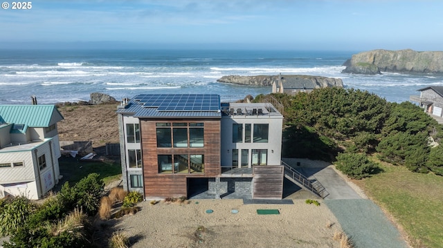 view of front facade featuring metal roof, solar panels, and a water view