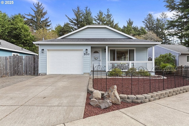 ranch-style home featuring an attached garage, covered porch, a shingled roof, fence, and concrete driveway